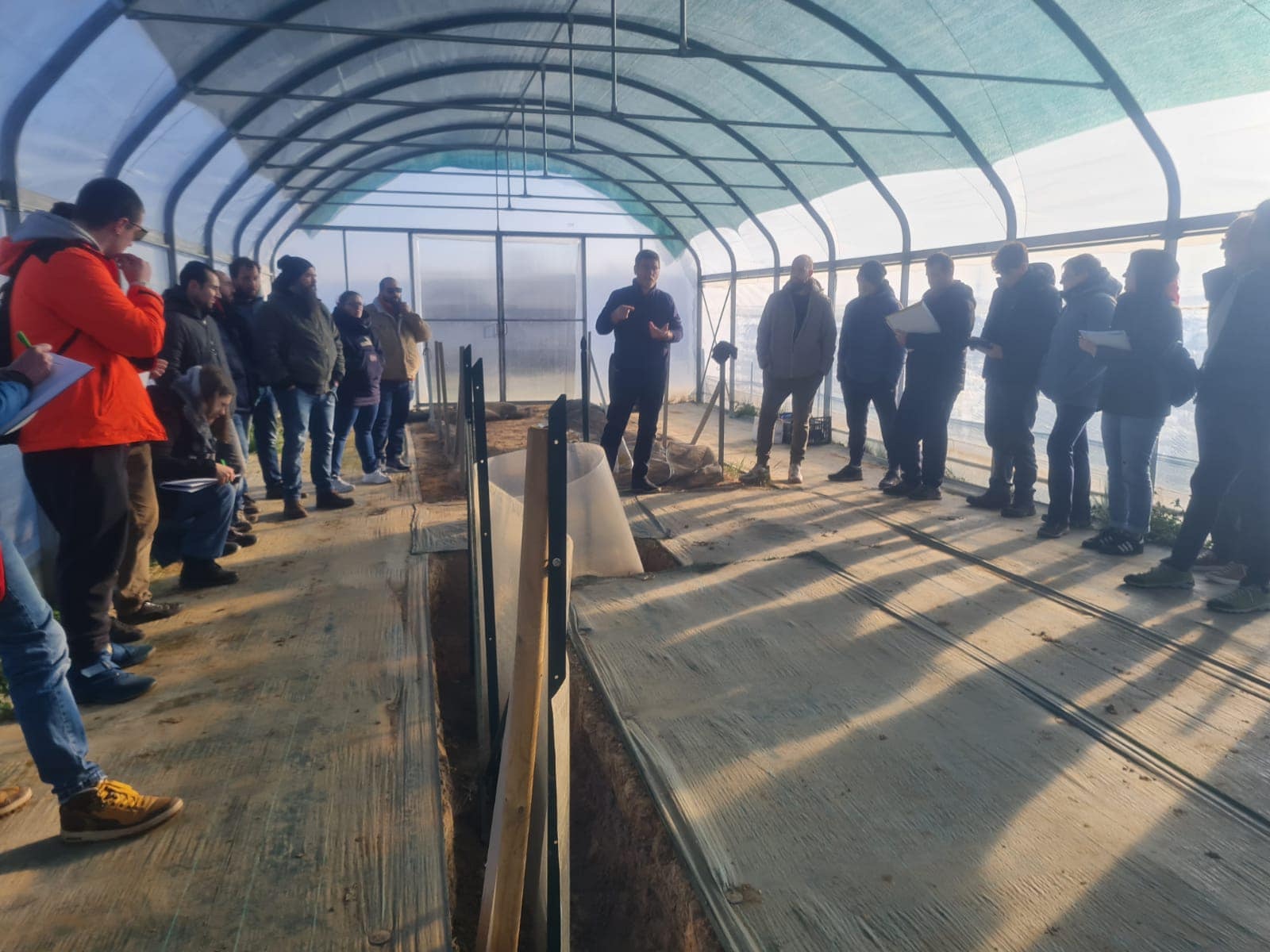 Un groupe de visiteurs sous une structure tunnel lors d’une visite technique.