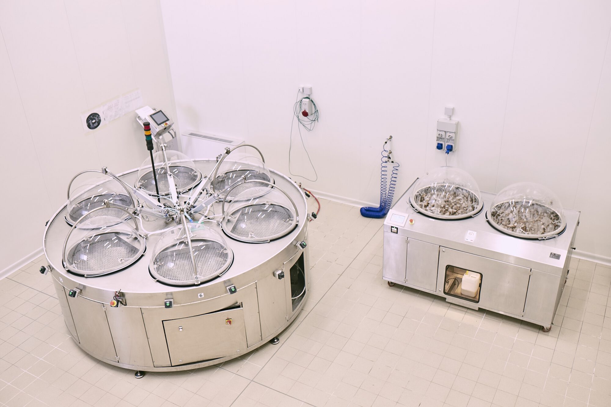 Due estrattori Muller in un laboratorio dalle pareti bianche: a sinistra il Fibonacci, tondo, con sei cupole trasparenti disposte a raggiera; a destra il One, rettangolare, con due cupole piene di chiocciole.